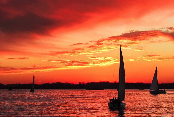 Sailboats on the water during a vibrant sunset