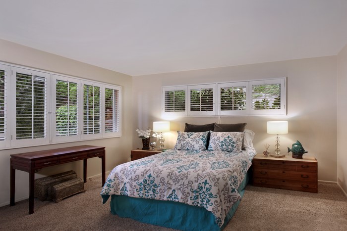 Bedroom with bed, lamps, and windows