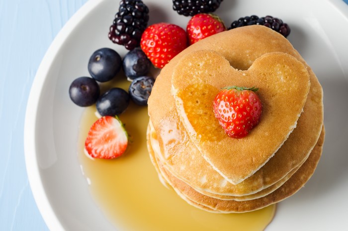Heart-shaped pancakes with berries and syrup