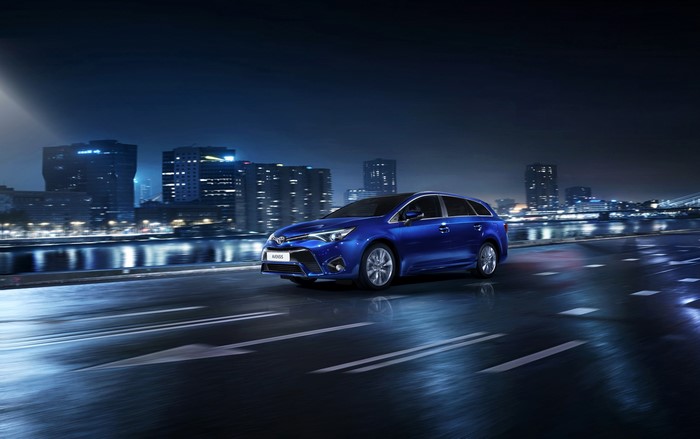 Blue 2015 Toyota Avensis SW driving at night