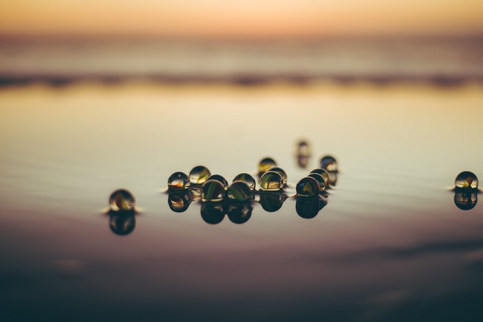 Marbles floating on water at sunset