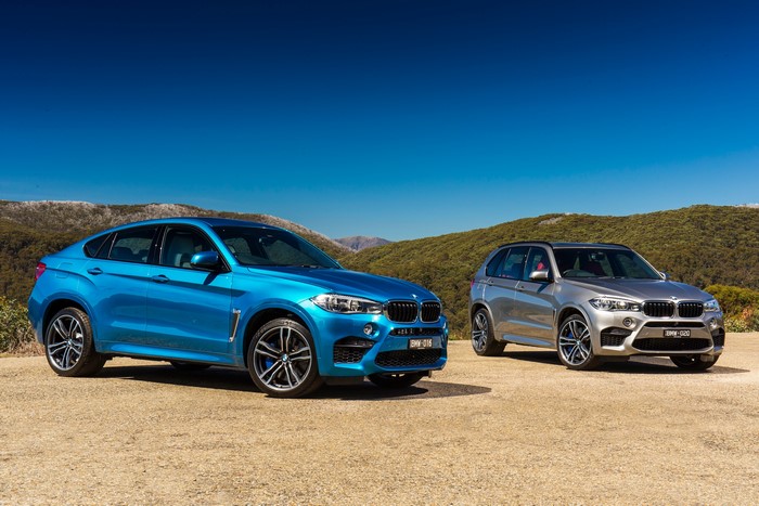 Two BMW M SUVs on a Hillside