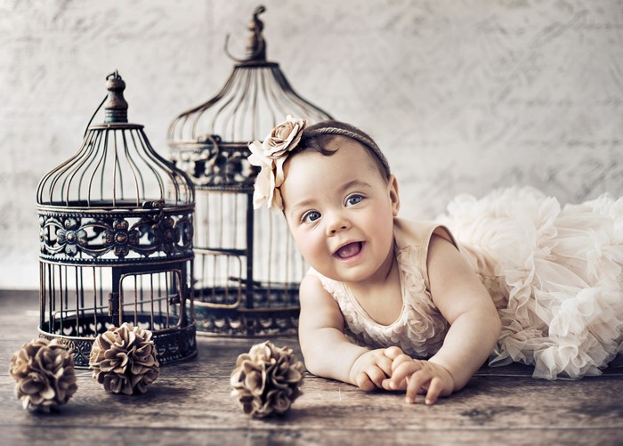 Baby girl in a dress with birdcages