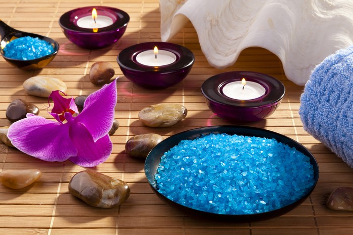 Spa setting with orchid, candles, stones, and blue salt