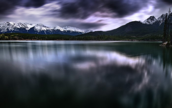 Pyramid Lake with Snow-Capped Mountains and Dark Clouds
