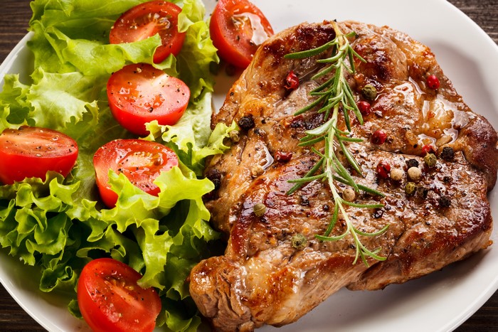Steak with salad and tomatoes on a plate