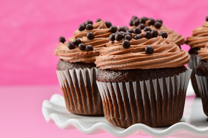Chocolate cupcakes with chocolate sprinkles on a cake stand