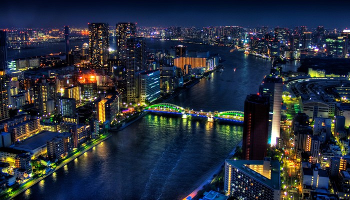 Tokyo cityscape at night with illuminated bridge over river