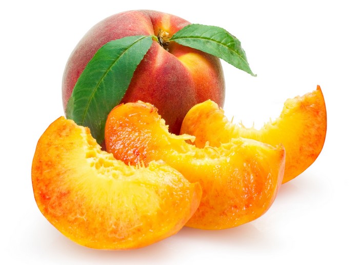 Whole and sliced peaches with leaves