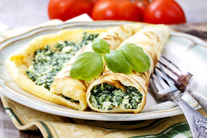Pancakes with spinach and cheese filling on a plate