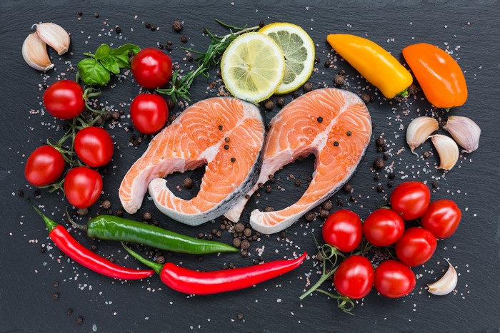 Salmon steaks with tomatoes, peppers, garlic, lemon, and herbs