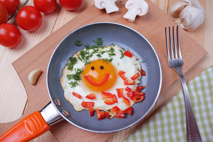 Fried egg with smiley face and vegetables