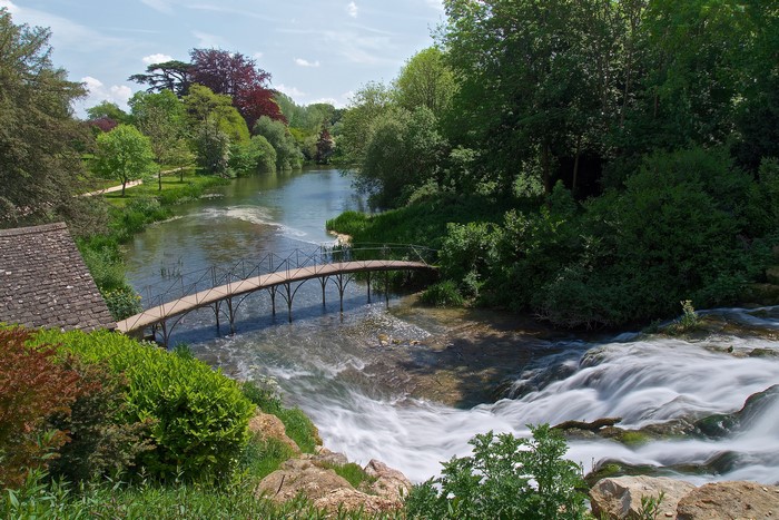 Bridge over a river with a waterfall and trees