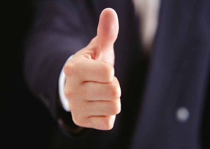 Man in suit giving thumbs up gesture