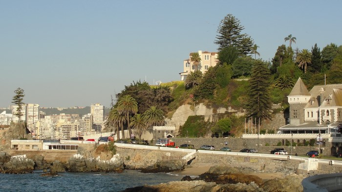 Coastal city with buildings on a hill and the ocean