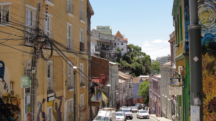 Street in Valparaiso, Chile with colorful buildings and graffiti