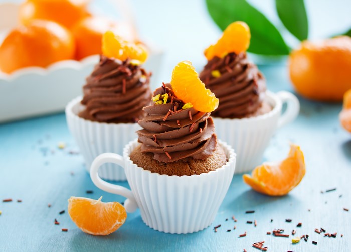 Chocolate cupcakes with mandarin slices and sprinkles