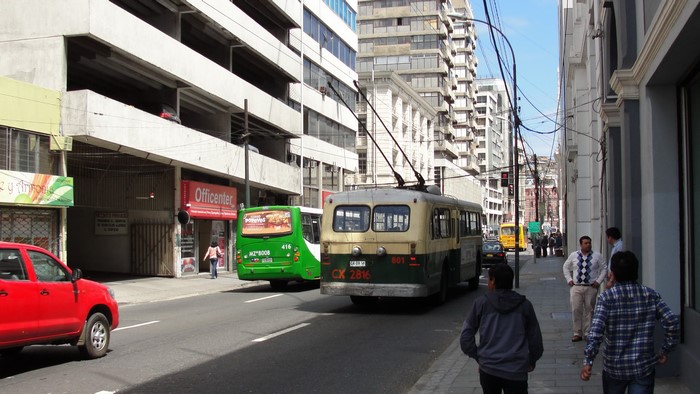 Trolleybus and green bus on a street in Valparaiso, Chile