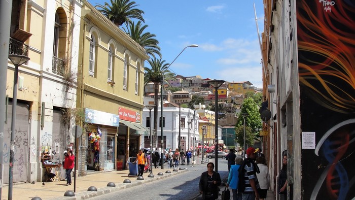 Street scene in Valparaiso, Chile with colorful houses and palm trees