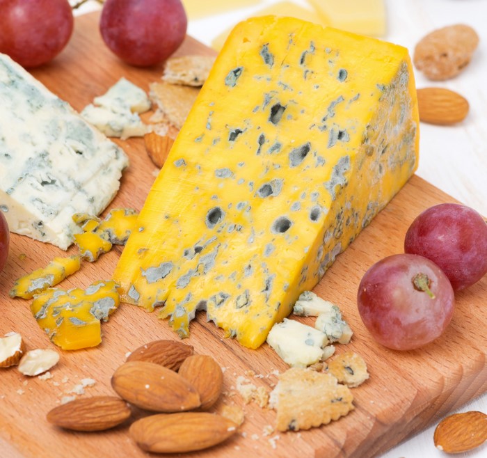 Cheese, Nuts, and Grapes on a Cutting Board