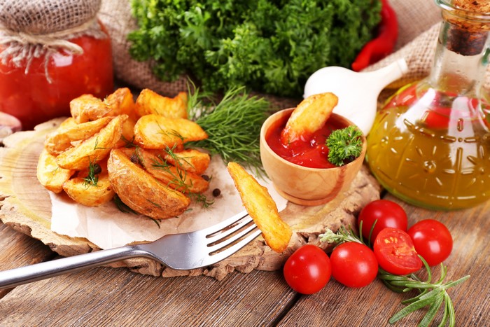 Potato wedges with ketchup and tomatoes