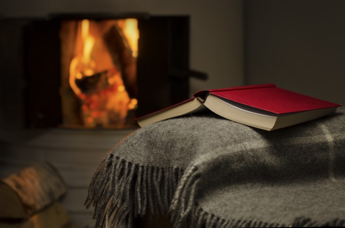Book on a blanket by a fireplace