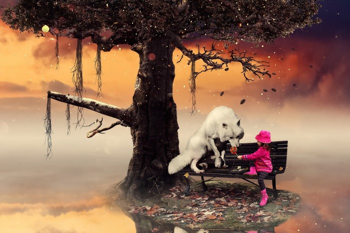 Girl feeding lollipop to white wolf under a tree