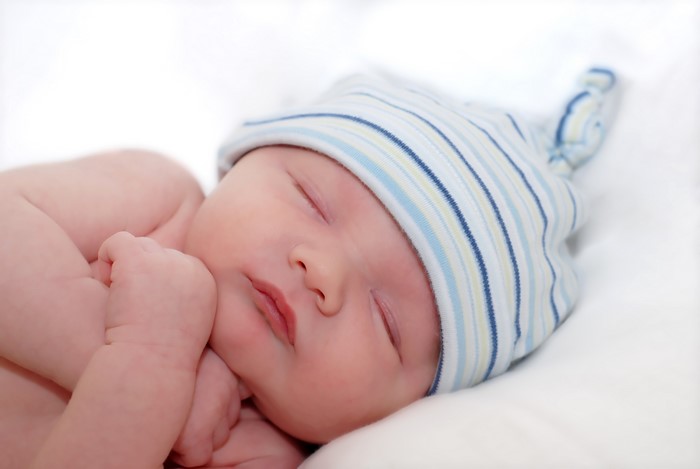 Infant sleeping wearing a striped winter hat