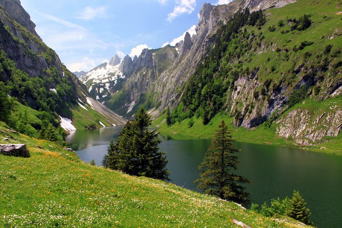 Lake in a mountain valley with snow-capped peaks