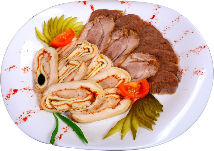 Sliced meats and roulades on a white plate