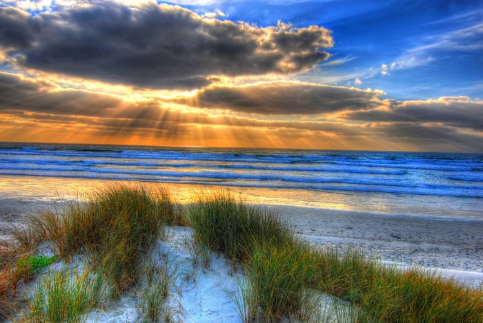 Beach with sand dunes and ocean at sunset