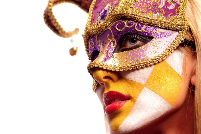 Woman wearing a Venetian mask and face paint