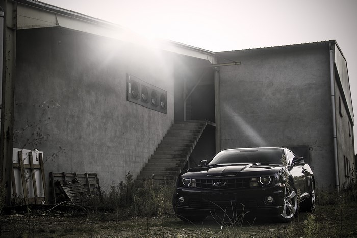 Black Chevrolet Camaro parked near a building