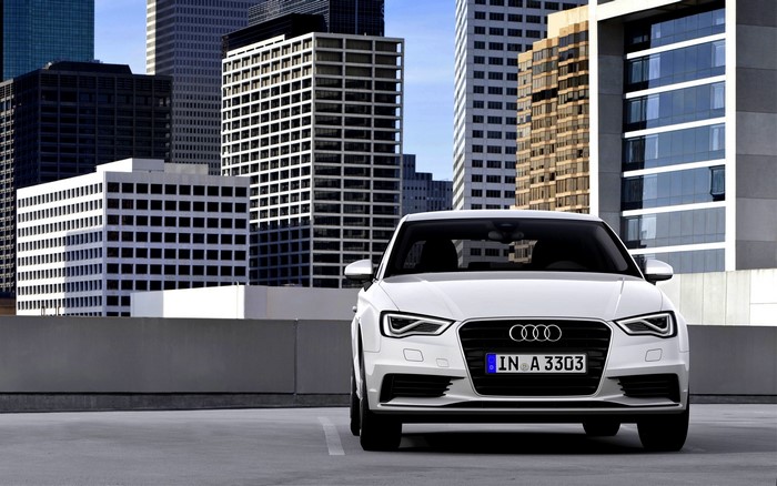 White Audi A3 parked in front of city buildings