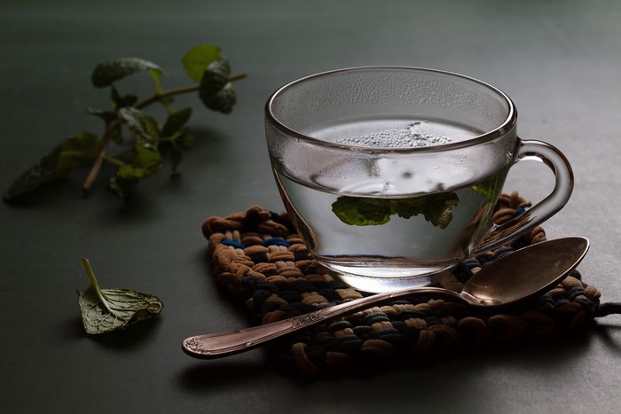 Cup of tea with mint leaves and spoon