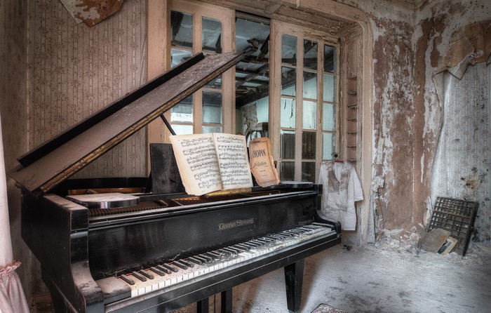 Grand piano in an abandoned room with sheet music