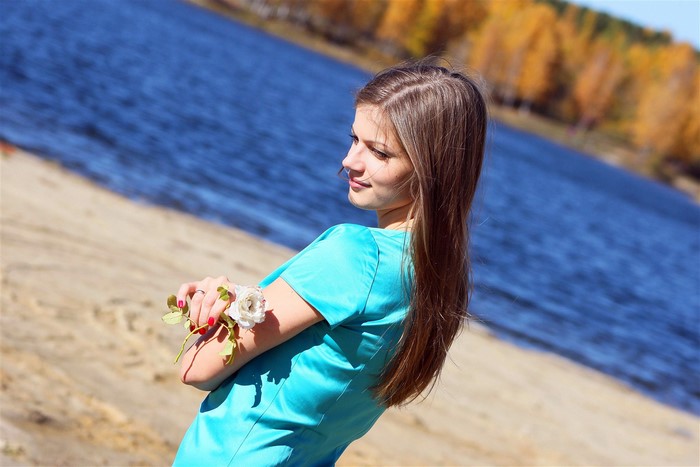 Woman with flower by the water