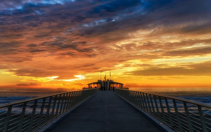 Pier at Sunrise over the Ocean with Dramatic Clouds