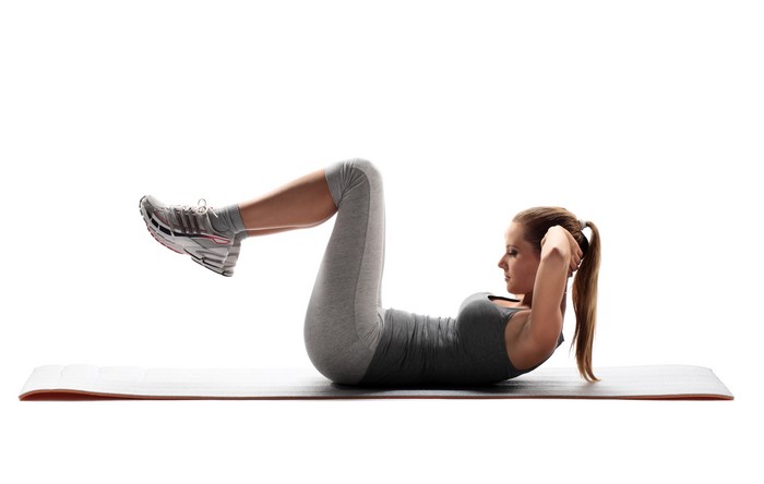 Woman doing crunches on a yoga mat
