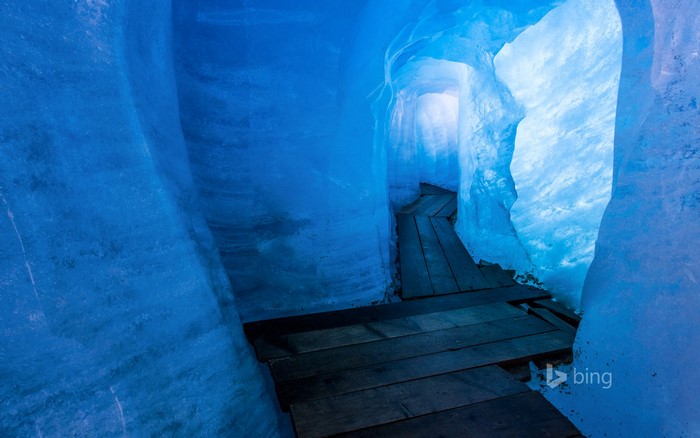 Wooden walkway through a blue ice cave in Switzerland
