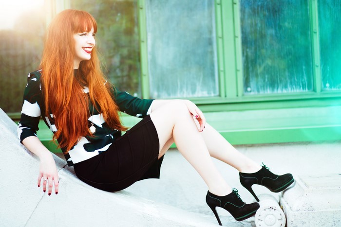 Redhead girl in black and white patterned top and black skirt