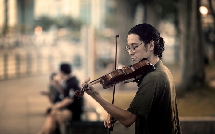 Man playing violin outdoors