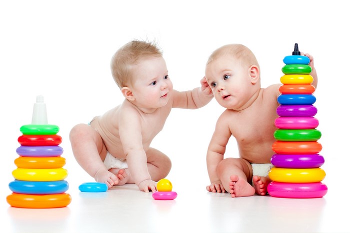 Two Infants Playing with Stacking Toys