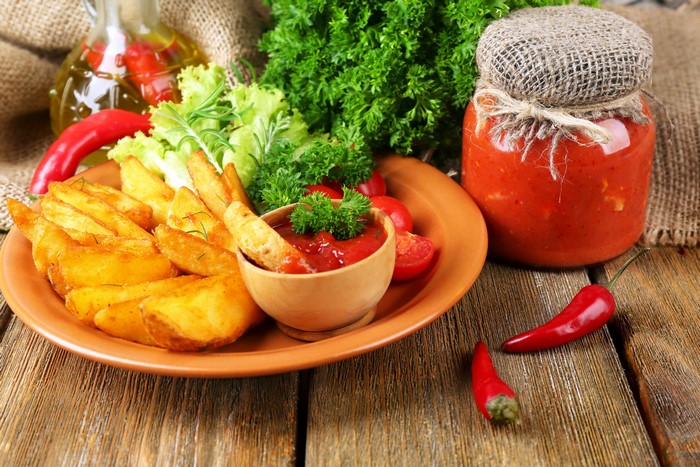 Potato wedges with ketchup and chili peppers