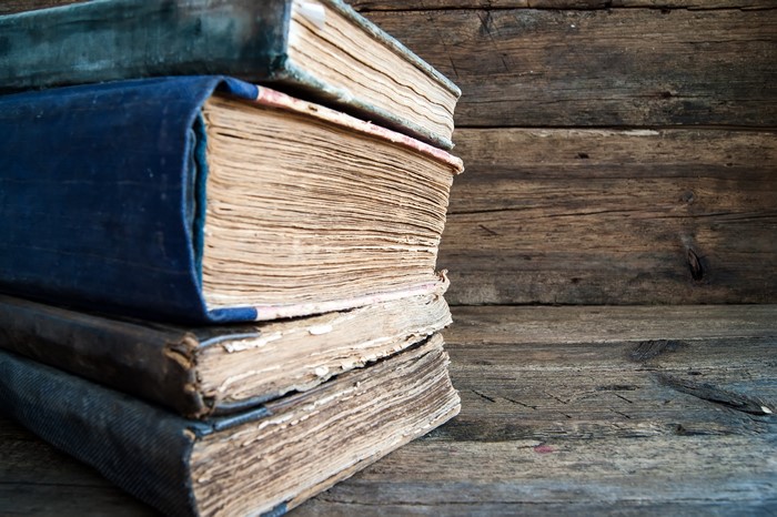 Stack of old books on wooden background