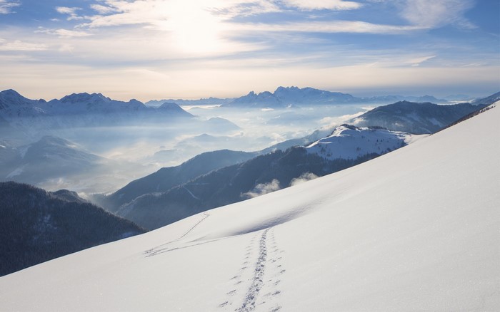 Snowy mountain range with fog in the valleys