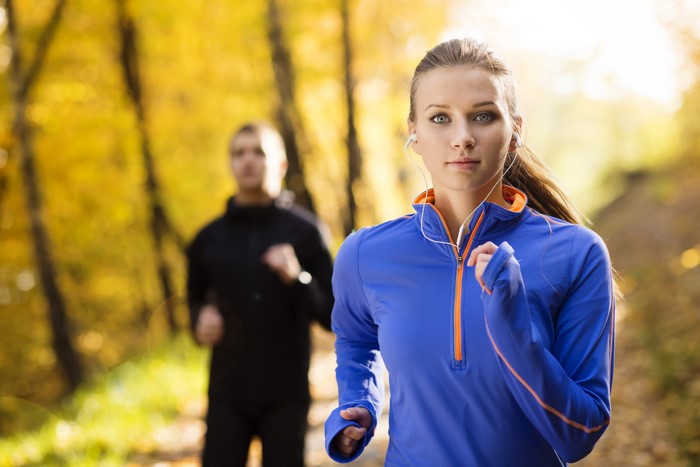 Two people running outdoors in autumn