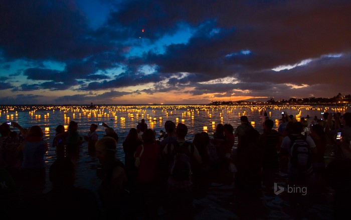 People release lanterns on the water at dusk