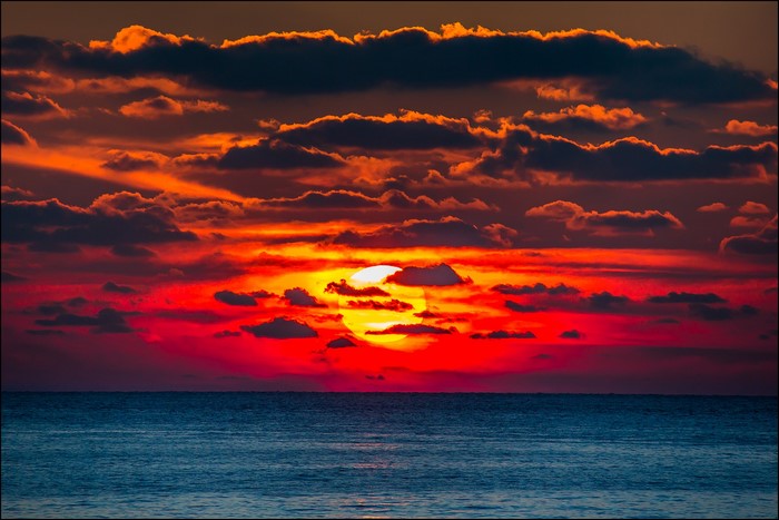 Sunset over the ocean with dramatic clouds