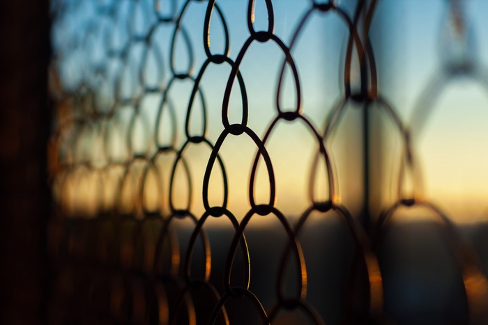 Closeup of a fence against a sunset sky